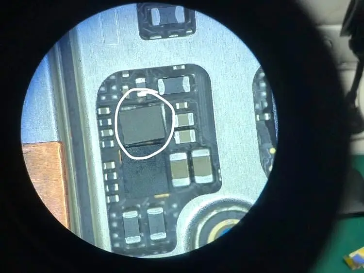 Mikroskop altında telefon anakartı; onarılacak entegre işaretlenmiş