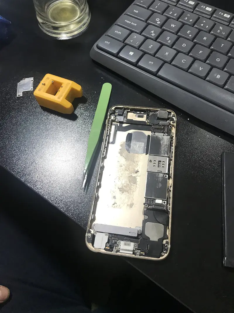 Ekranı sökülmüş iPhone; iç kasa ve anakart görünüyor