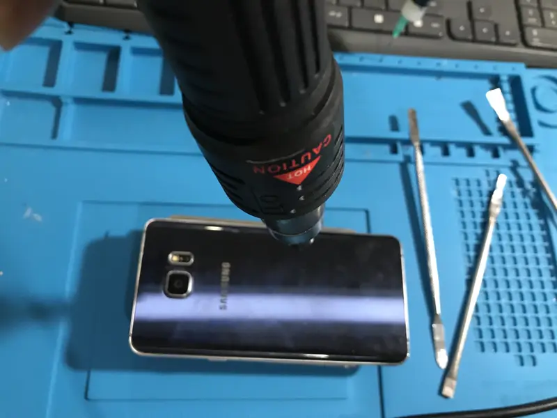 Tamir matında Samsung Galaxy Note 5; şarj soketi değişimi için arka cam ısıtılarak sökülüyor
